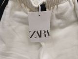 a close up of a white pants with a tag on it
