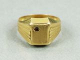 Gros plan sur une bague en or ornée d'une pierre rouge