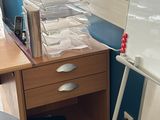 a stack of papers on a desk next to a chair