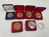 six types différents de pièces d'or et d'argent dans un coffret rouge