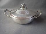 an antique silver plated casserole with a lid and handles