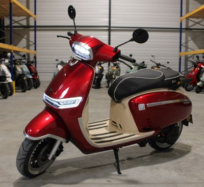 un scooter rouge garé dans un entrepôt, avec d'autres scooters en arrière-plan