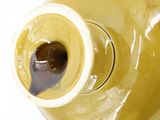a yellow vase with a brown lid on a white table