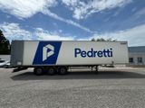 a white semi truck with a blue and white logo parked in a parking lot