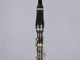 a close up of a clarinet on a clear surface with a gray background