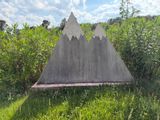 a concrete triangle in the middle of a grassy field
