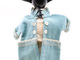 un mannequin vêtu d'un manteau bleu et d'un chapeau