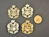 four gold and silver badges and a coin