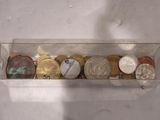 une boîte transparente remplie de différentes pièces de monnaie