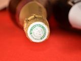a close up of a bottle of wine on a red surface
