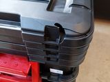 a black case with a red handle on the floor