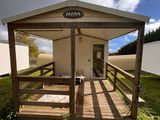 une petite maison avec un porche au milieu de la pelouse
