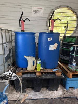 two blue barrels sitting on a pallet in a garage