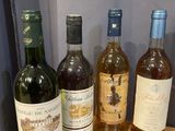 several bottles of wine are lined up on a wooden shelf