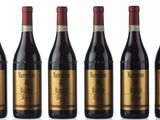six bottles of red wine are lined up in a row