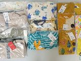 beaucoup de vêtements de bébé posés sur la table
