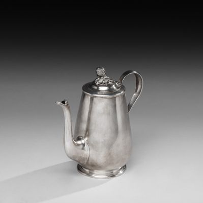 une théière ancienne en argent surmontée d'un oiseau