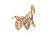 a close up of a gold and white brooch with a bird on it