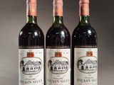 trois bouteilles de vin posées sur une table l'une à côté de l'autre