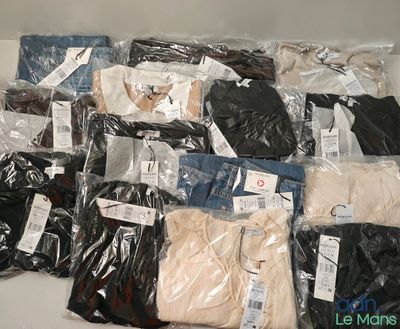 beaucoup de vêtements pour hommes dans des sacs posés sur une table