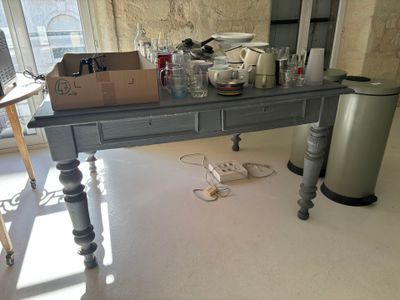 une table sur laquelle sont posés de nombreux objets, dans la pièce