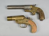 pair of old brass revolvers on a white surface