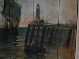 a painting on the wall of a building with a boat in the water