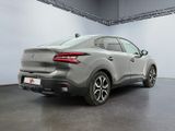 the rear end of a grey car in a large room