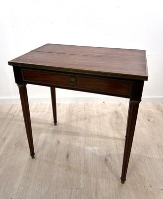 une petite table munie d'un tiroir, posée sur un parquet en bois massif