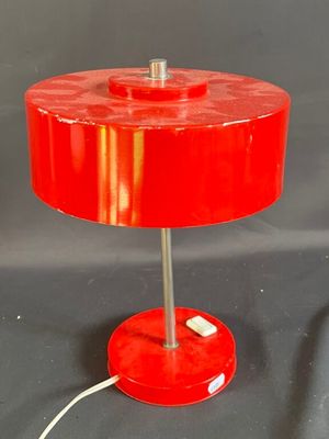 une lampe de table rouge posée sur une table noire