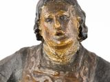 an old statue of a woman holding a bowl of food