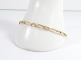 a close up of a gold chain bracelet on a mannequin head