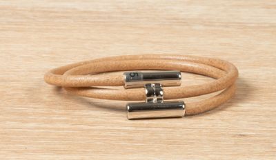 a close up of a pair of leather bracelets on a wooden surface
