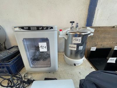 a laptop computer sitting on a table next to a water dispenser