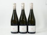 trois bouteilles de vin posées sur une table l'une à côté de l'autre