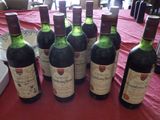 plusieurs bouteilles de vin posées sur une table recouverte d'une nappe rouge