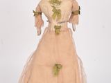 an antique doll of a woman in a dress and hat