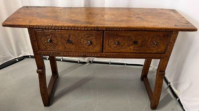 an old wooden table with two drawers on top of it