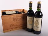 two bottles of wine in a wooden box on a white surface