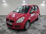 La petite voiture rouge est garée dans le garage, sur le sol à carreaux.