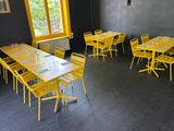 des tables et des chaises dans une pièce dotée d'une grande fenêtre et d'un mur noir