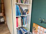 a bookshelf in the corner of a room with a lot of books on it