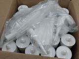 a cardboard box filled with white candles and wrapped in plastic