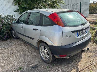 une petite voiture argentée garée devant un immeuble
