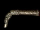 a close up of a silver and wood handle on a cane