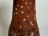 a brown vase sitting on a table with a white background