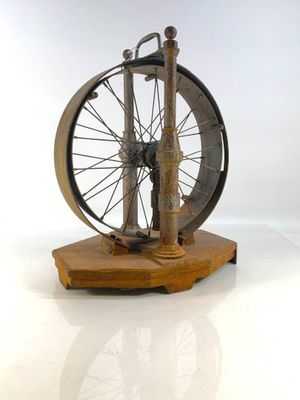 une petite maquette de rouet posée sur un socle en bois