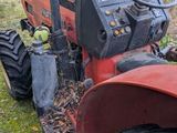 a red tractor that is parked in the grass