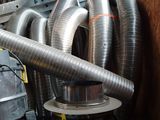 a pile of metal pipes and a blower in a room