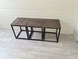 three wooden tables sitting on top of a tiled floor